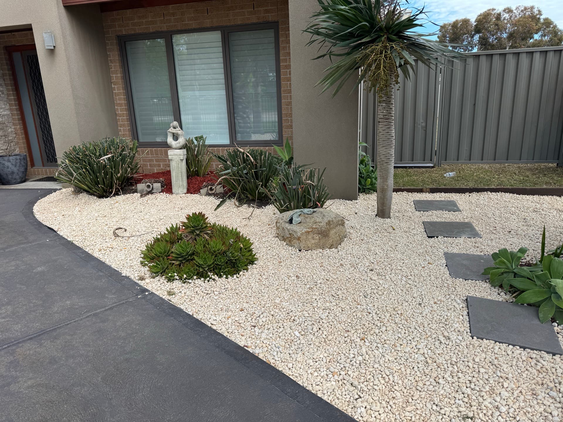 Neat garden bed with pebbles and succulents after a tidy-up